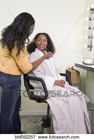 Stock Photo - African woman having makeup applied. Fotosearch