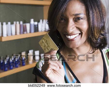 Stock Photo - African woman holding credit card. Fotosearch