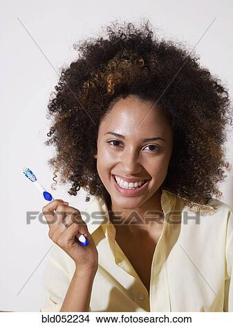 Picture - African woman holding toothbrush. Fotosearch