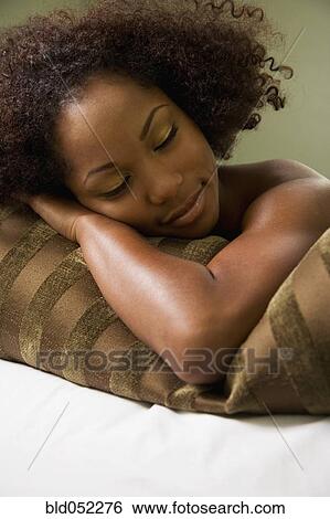 African woman laying on pillow View Large Photo Image Stock Photograph - African woman laying on pillow. Fotosearch