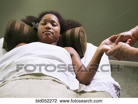 Stock Image - African woman receiving massage. Fotosearch