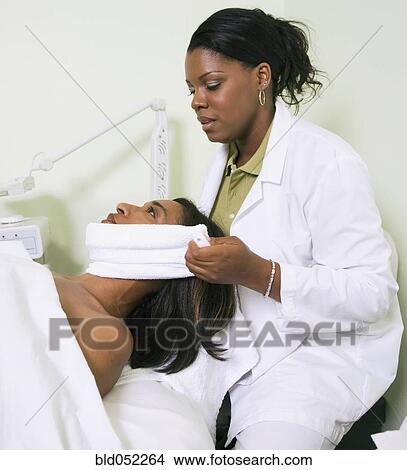 Picture - African woman receiving spa facial treatment. Fotosearch