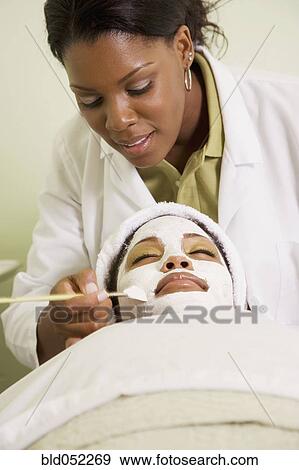 Stock Photo - African woman receiving spa facial treatment. Fotosearch