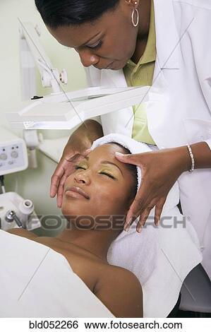 Stock Photograph - African woman receiving spa facial treatment. Fotosearch