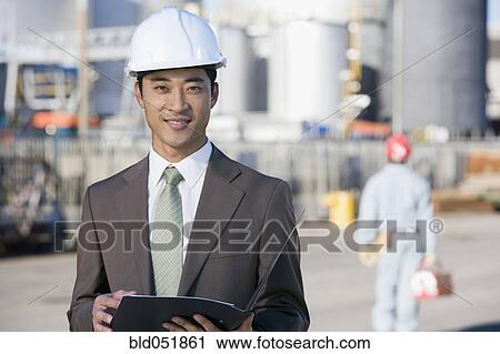 Asian businessman wearing hardhat View Large Photo Image Stock Image - Asian businessman wearing hardhat. Fotosearch