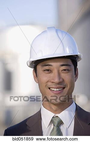 Asian businessman wearing hardhat View Large Photo Image Stock Photo - Asian businessman wearing hardhat. Fotosearch