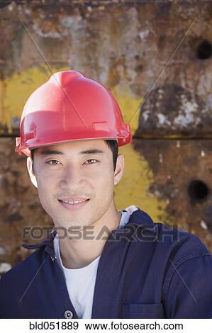 Stock Photo - Asian male construction worker wearing hardhat. Fotosearch