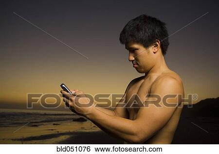 Asian man dialing cell phone View Large Photo Image Stock Photograph - Asian man dialing cell phone. Fotosearch