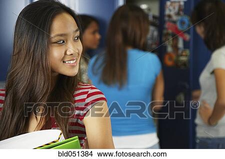 Picture - Asian teenaged girl in front of school lockers. Fotosearch