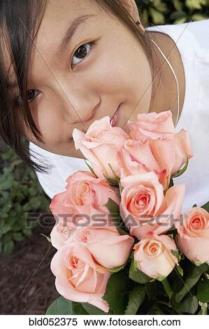 Stock Photography - Asian woman holding flowers. Fotosearch