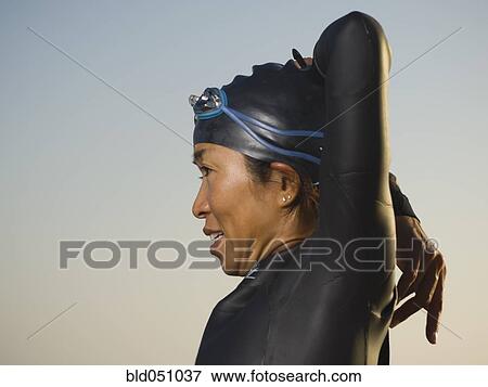 Asian woman stretching in wetsuit and goggles View Large Photo Image Stock Photo - Asian woman stretching in wetsuit and goggles. Fotosearch