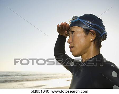 Stock Image - Asian woman wearing wetsuit and goggles. Fotosearch