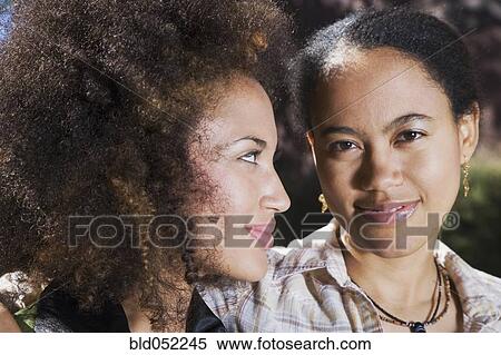 Stock Photography - Close up of African woman smiling at sister. Fotosearch