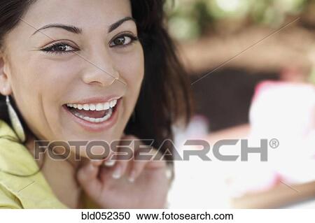 Stock Image - Close up of Hispanic woman laughing. Fotosearch