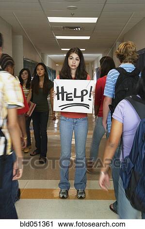 Stock Image - Female teenaged student holding Help sign. Fotosearch