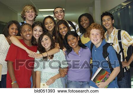 Stock Image - Group of multi-ethnic teenagers in school hallway. Fotosearch
