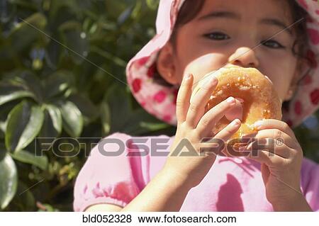 Hispanic baby girl eating doughnut View Large Photo Image Stock Photo - Hispanic baby girl eating doughnut. Fotosearch