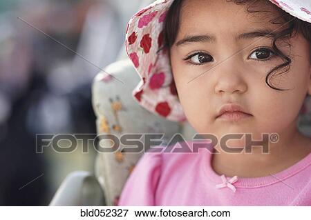 Stock Photo - Hispanic baby girl wearing hat. Fotosearch