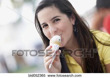 Stock Photography - Hispanic girl eating ice cream cone. Fotosearch