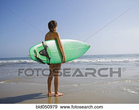 Hispanic girl holding surfboard View Large Photo Image Stock Photo - Hispanic girl holding surfboard. Fotosearch