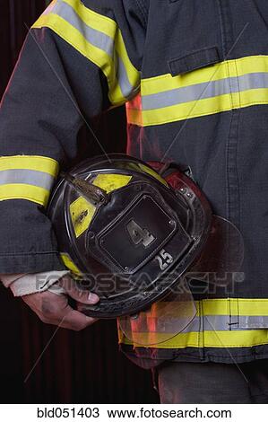 Hispanic male firefighter holding helmet View Large Photo Image Stock Image - Hispanic male firefighter holding helmet. Fotosearch