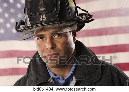 Hispanic male firefighter in front of American flag View Large Photo Image Picture - Hispanic male firefighter in front of American flag. Fotosearch