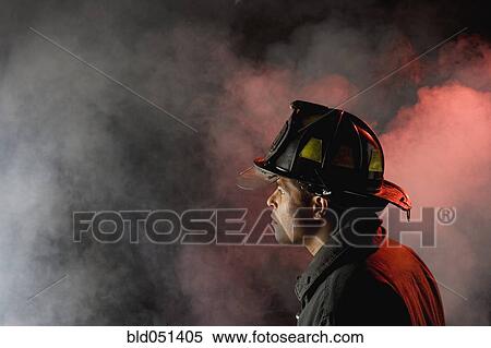 Hispanic male firefighter looking into smoke View Large Photo Image Stock Photography - Hispanic male firefighter looking into smoke. Fotosearch