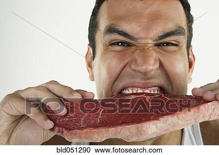 Hispanic man biting raw beef View Large Photo Image Stock Image - Hispanic man biting raw beef. Fotosearch