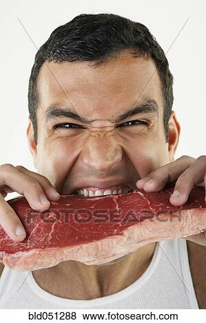 Hispanic man biting raw beef View Large Photo Image Stock Photo - Hispanic man biting raw beef. Fotosearch