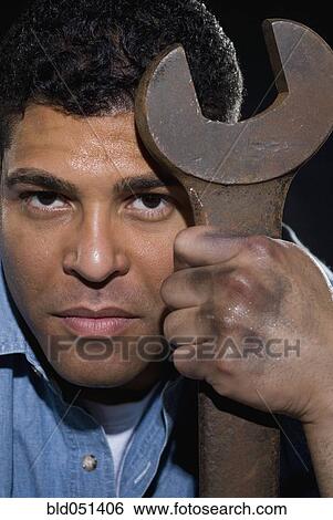 Hispanic man holding large wrench View Large Photo Image Stock Photograph - Hispanic man holding large wrench. Fotosearch