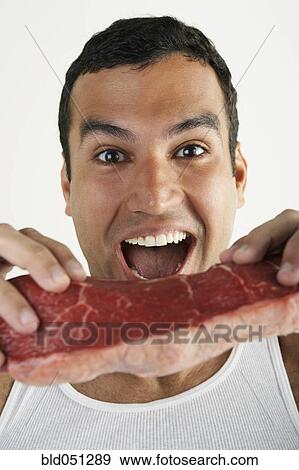 Hispanic man hooding raw beef View Large Photo Image Stock Photo - Hispanic man hooding raw beef. Fotosearch