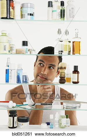 Hispanic man looking in medicine cabinet View Large Photo Image Stock Image - Hispanic man looking in medicine cabinet. Fotosearch