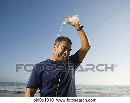 Hispanic man pouring water over head View Large Photo Image Stock Image - Hispanic man pouring water over head. Fotosearch