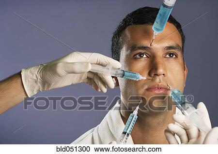 Stock Image - Hispanic man receiving injections in face. Fotosearch