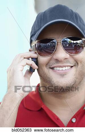 Stock Image - Hispanic man talking on cell phone. Fotosearch