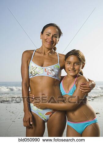 Stock Image - Hispanic mother and daughter hugging. Fotosearch