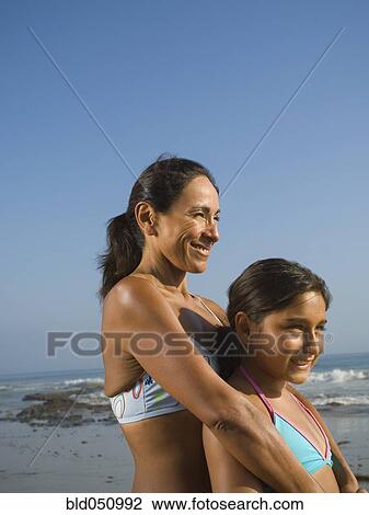 Stock Image - Hispanic mother and daughter hugging. Fotosearch