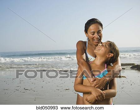 Stock Image - Hispanic mother and daughter hugging. Fotosearch