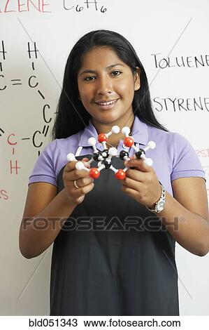 Stock Image - Hispanic teenaged girl in science class. Fotosearch