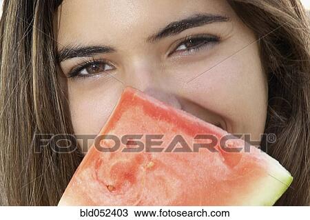 Stock Image - Hispanic woman holding watermelon slice. Fotosearch