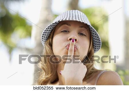 Stock Photography - Hispanic woman kissing finger. Fotosearch