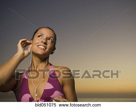 Hispanic woman listening to mp3 player View Large Photo Image Stock Photography - Hispanic woman listening to mp3 player. Fotosearch