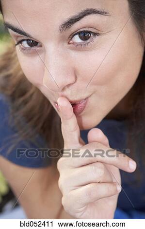 Stock Image - Hispanic woman shushing. Fotosearch
