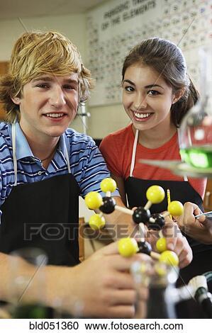 Stock Image - Male and female teenagers in science class. Fotosearch