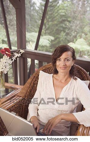 Stock Photography - Mature woman typing on laptop. Fotosearch