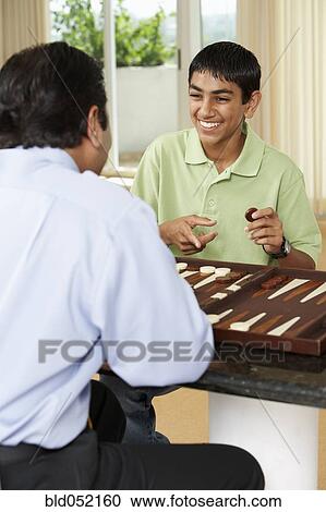 Stock Image - Middle Eastern father and son playing game. Fotosearch