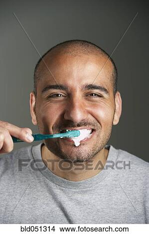 Picture - Middle Eastern man brushing teeth. Fotosearch