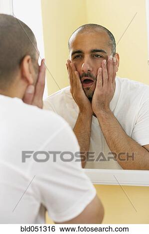 Middle Eastern man looking in mirror View Large Photo Image Stock Photograph - Middle Eastern man looking in mirror. Fotosearch
