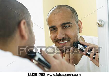 Middle Eastern man shaving with electric razor View Large Photo Image Stock Photo - Middle Eastern man shaving with electric razor. Fotosearch