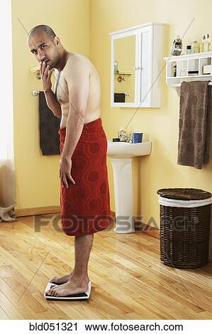 Middle Eastern man standing on scale View Large Photo Image Stock Image - Middle Eastern man standing on scale. Fotosearch